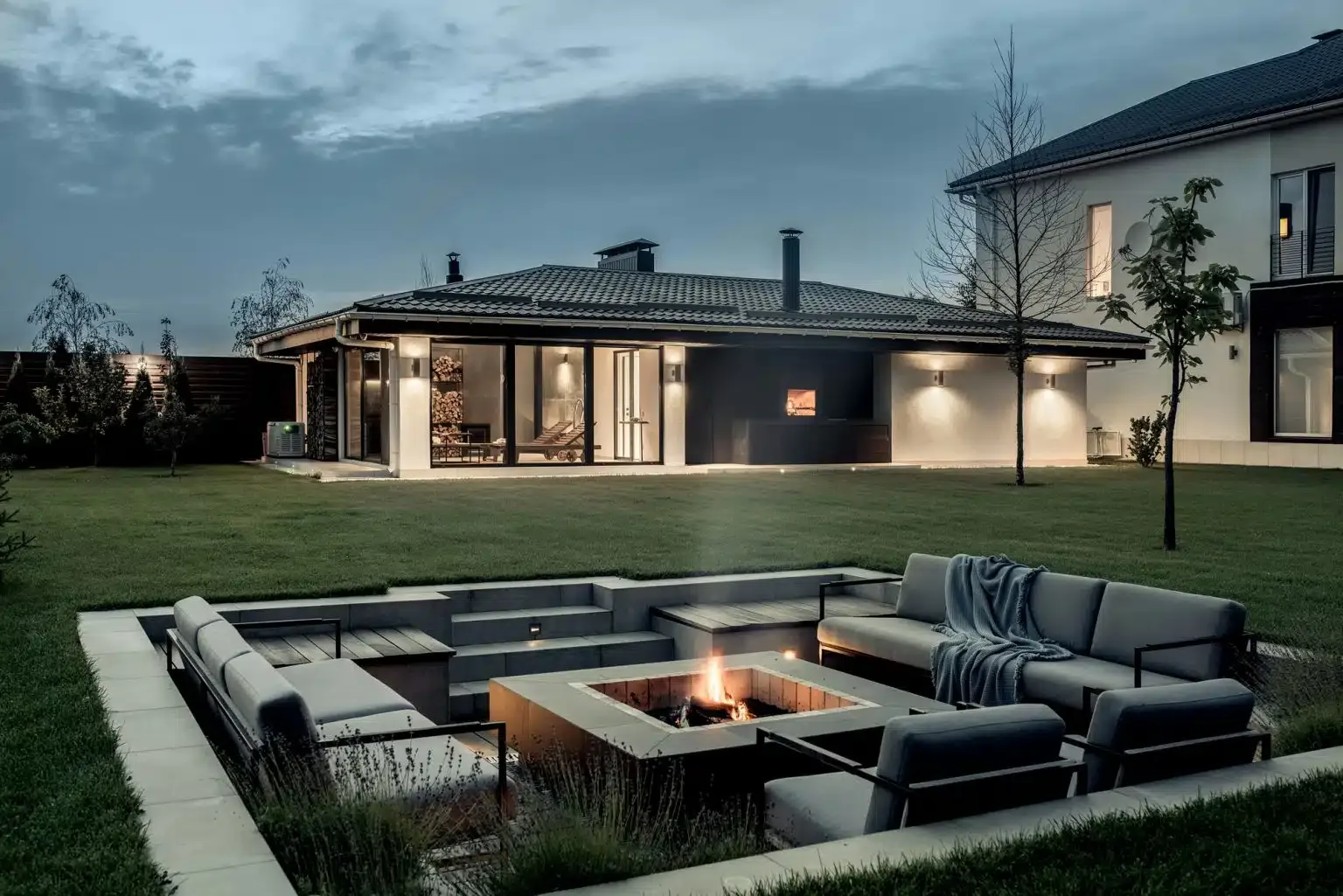 Sunken fire pit lounge area in a landscaped backyard