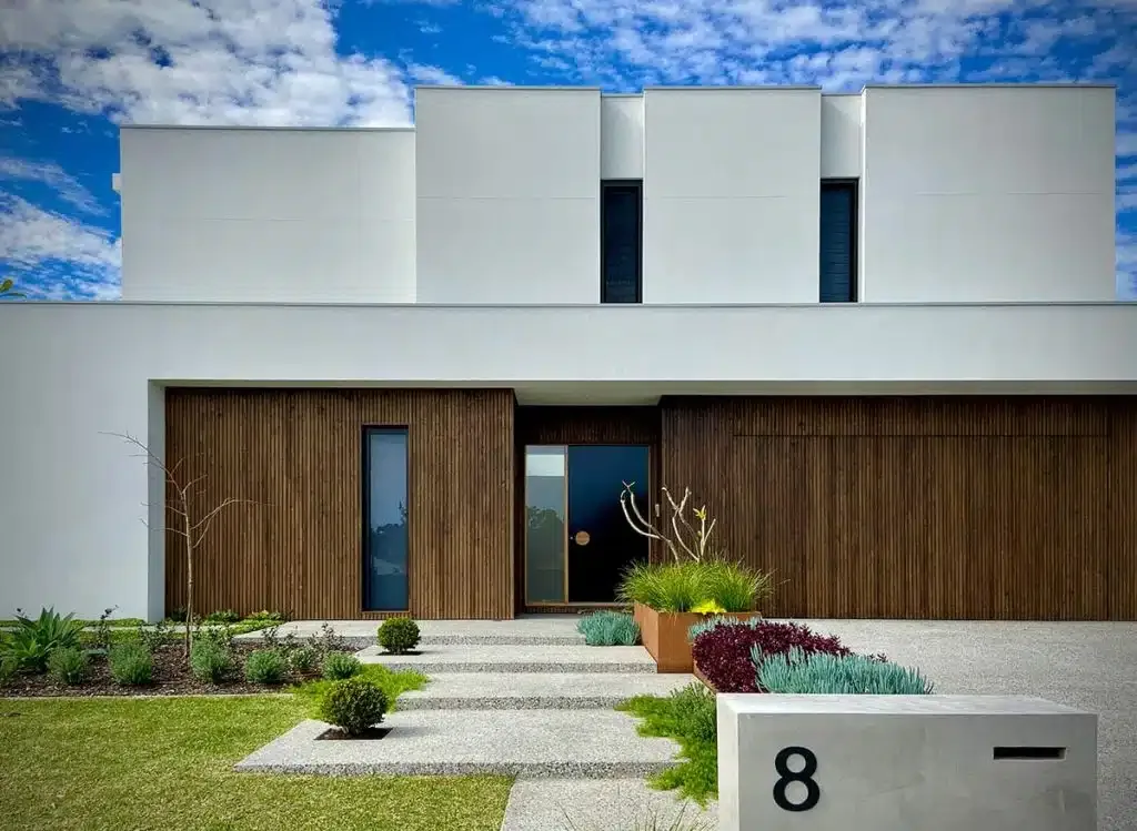Modern home entrance with a designed garden bed and paved pathway
